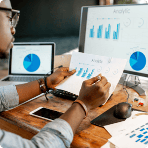 High-resolution image of a professional analyzing business reports with charts and graphs on computer screens, demonstrating data analytics and insights for digital transformation and strategic decision-making.